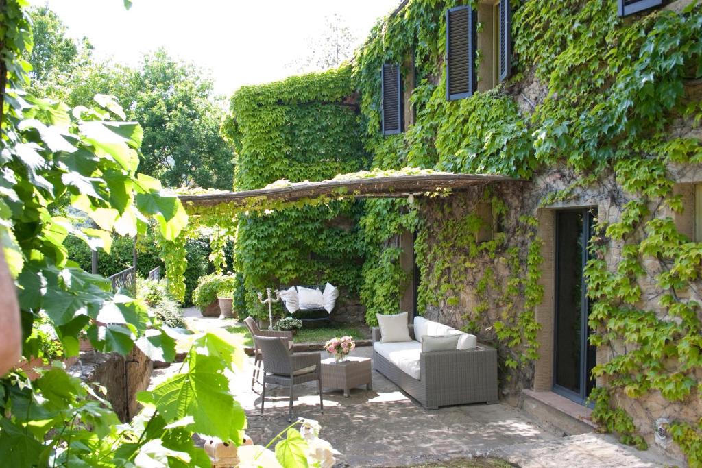 a garden with a couch and chairs in front of a building at Villa Topazio in Cortona