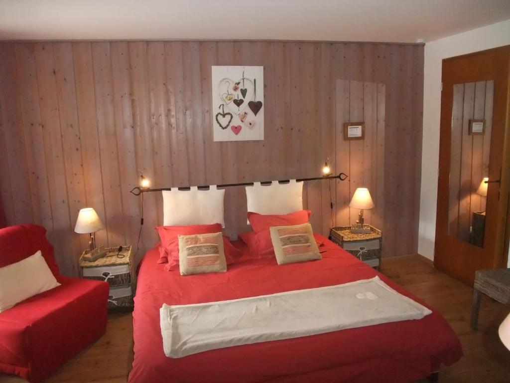 1 dormitorio con cama roja y sofá rojo en Le Domaine du Grand Cellier Chambres d'hôtes en Savoie, en Tournon