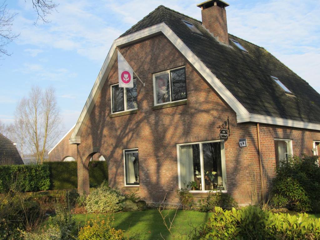 uma casa castanha com um telhado preto em Bed & Breakfast "Bij de Trekgaten" em Hollandscheveld