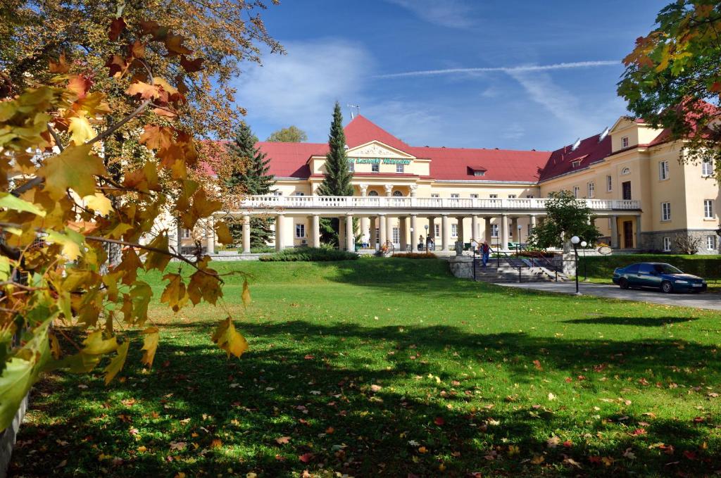 un gran edificio blanco con techo rojo en Nowe Łazienki Mineralne en Krynica Zdrój