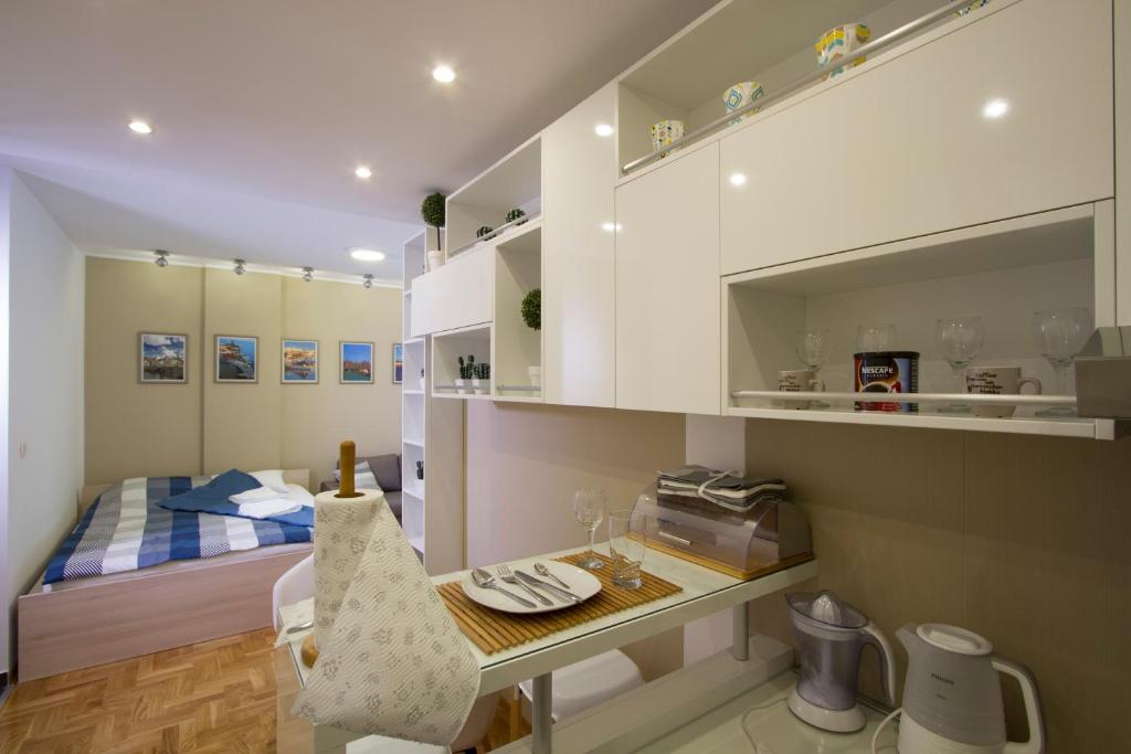 a bedroom with a bed and a desk with a table at Lux Life Apartment in Belgrade