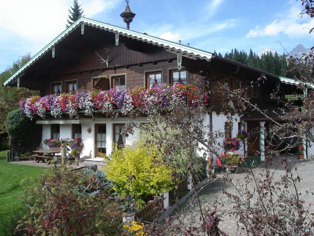 Una casa con flores al costado. en Landhaus Wiederkehr, en Ramsau am Dachstein