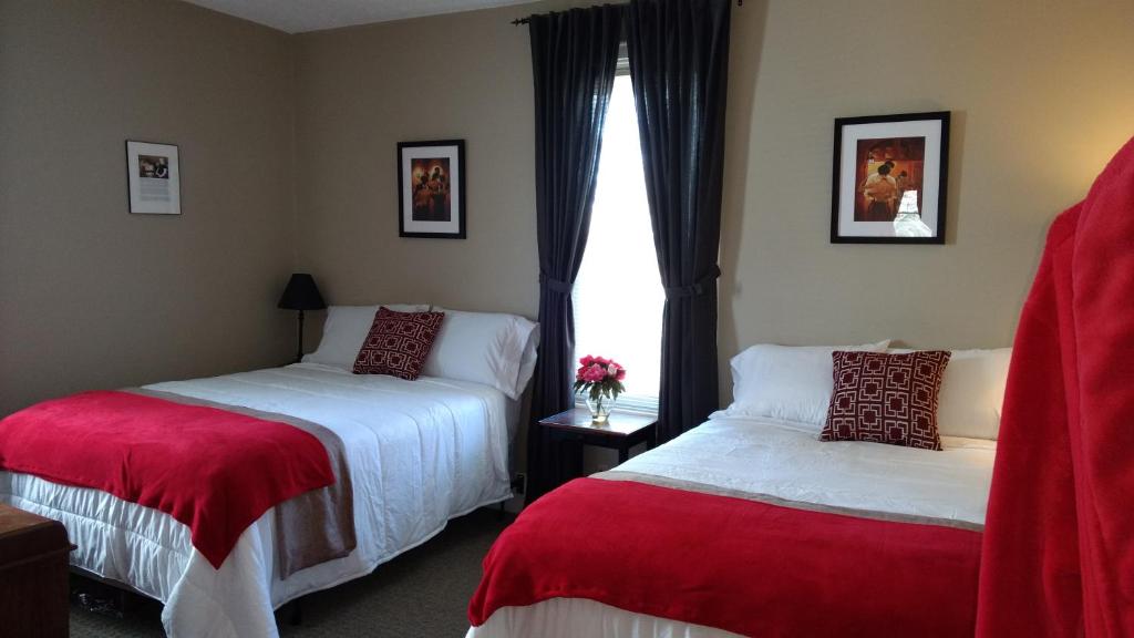 a hotel room with two beds and a window at Carraway Guest House in Canal Winchester