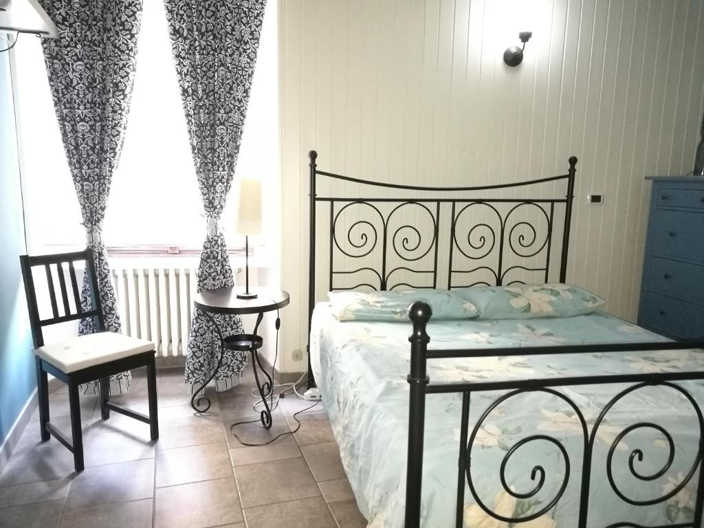 Schlafzimmer mit einem Bett, einem Tisch und einem Fenster in der Unterkunft Greppi Apartment in Novara
