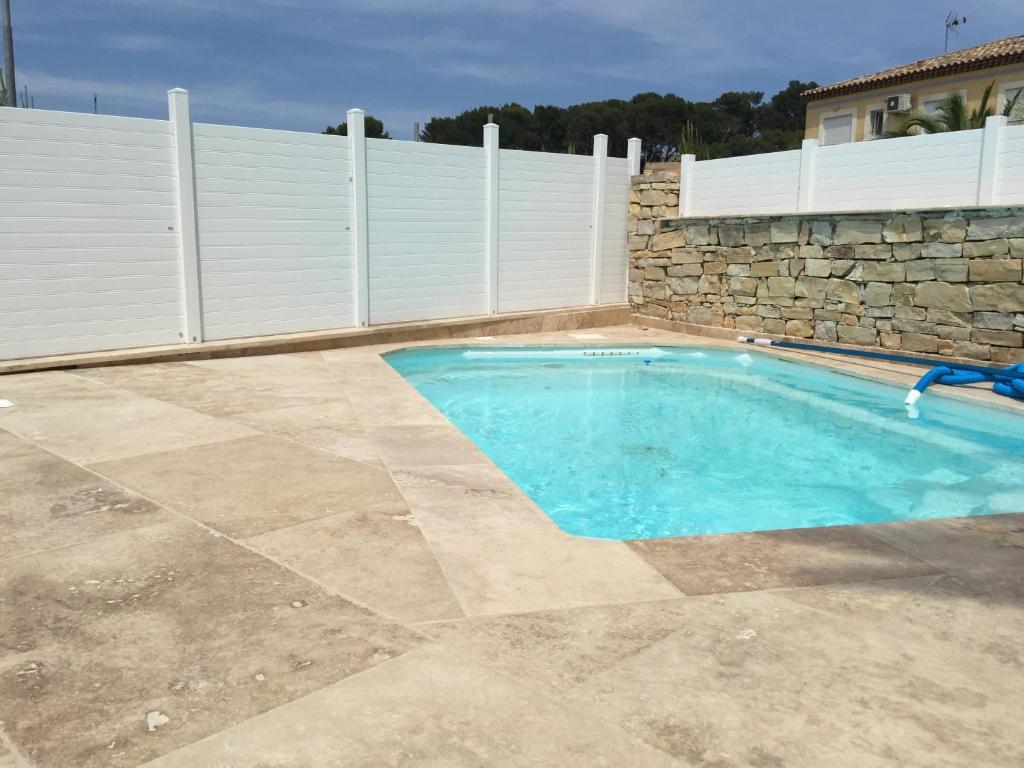 a swimming pool in a backyard with a fence at Residence Les Jardins De Lea in La Seyne-sur-Mer