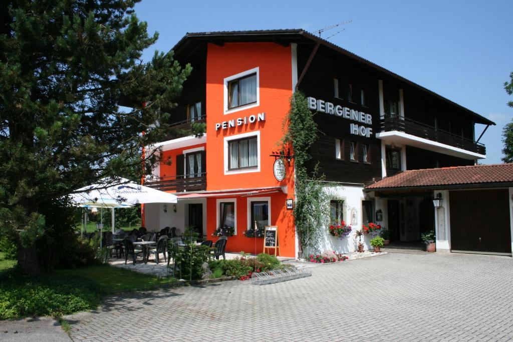 ein orangefarbenes Gebäude mit Tischen und Stühlen davor in der Unterkunft Bergener Hof in Bergen