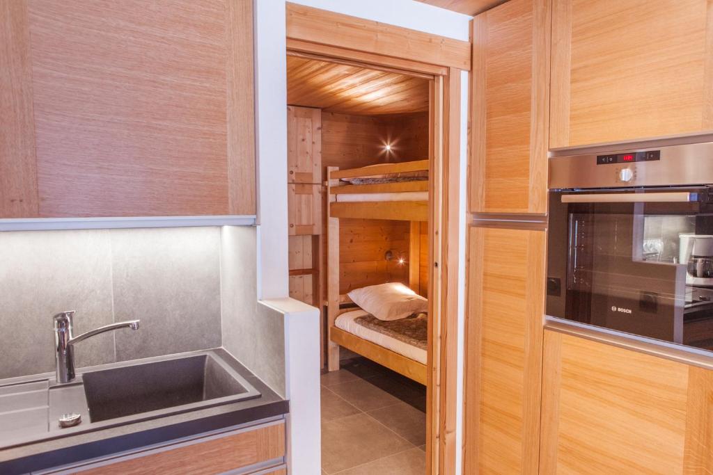 a small room with a sink and a kitchen with bunk beds at Studio Beauregard in Le Grand-Bornand