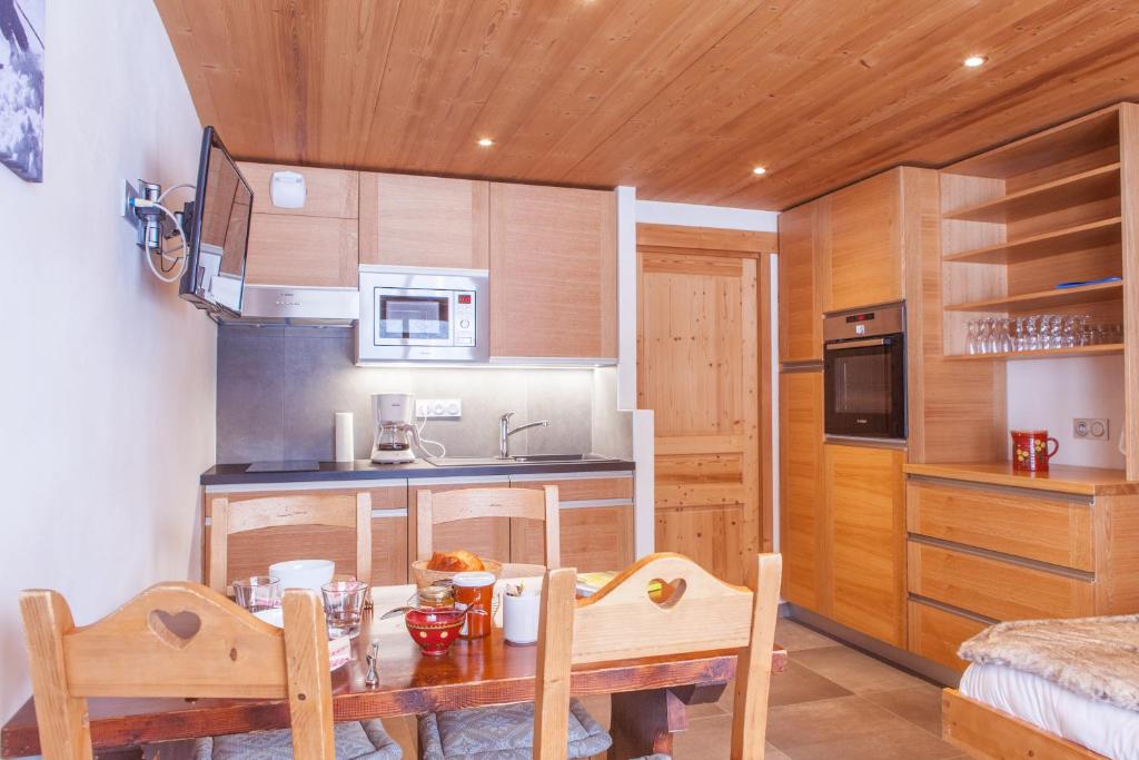 a small kitchen with a table and a microwave at Studio Beauregard in Le Grand-Bornand