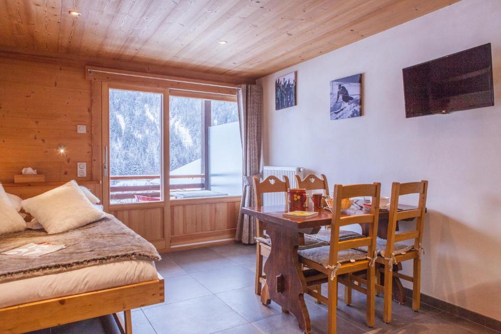 a bedroom with a table and chairs and a bed at Studio Beauregard in Le Grand-Bornand