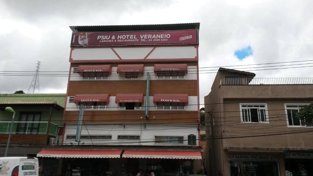a building with a sign on the side of it at Psiu Lanches e Hotel Veraneio in Posse