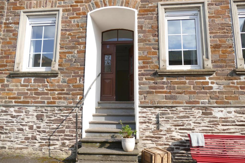 a brick building with a door and a red bench at Herrenhaus - Weingut Freiherr v. Landenberg in Ediger-Eller