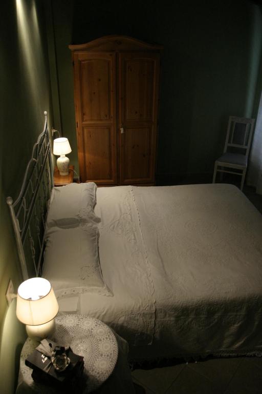 a bedroom with a bed with two lamps and a table at Silenzio e Buio in Calizzano