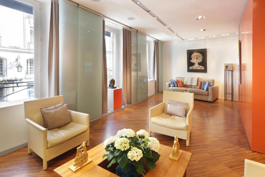 パリにあるTerrace Matignon Apartmentのリビングルーム(椅子、花のテーブル付)