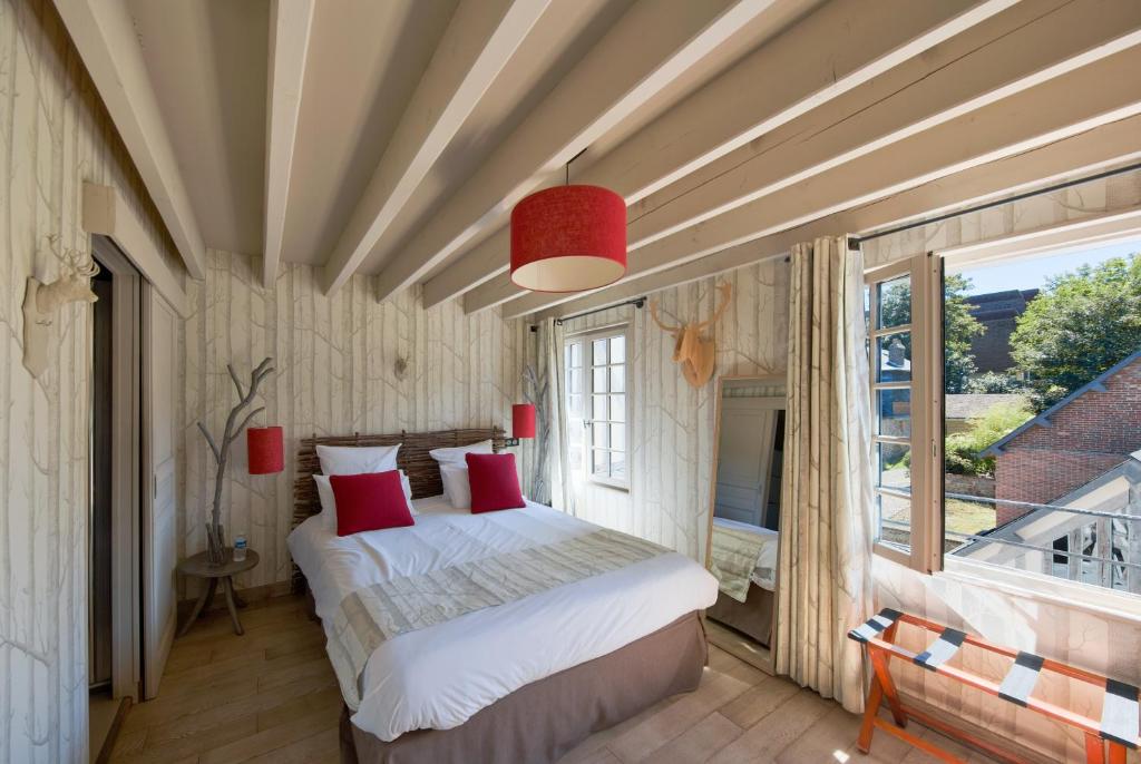 a bedroom with two beds and a large window at Hotel Du Grand Cerf & Spa in Lyons-la-Forêt