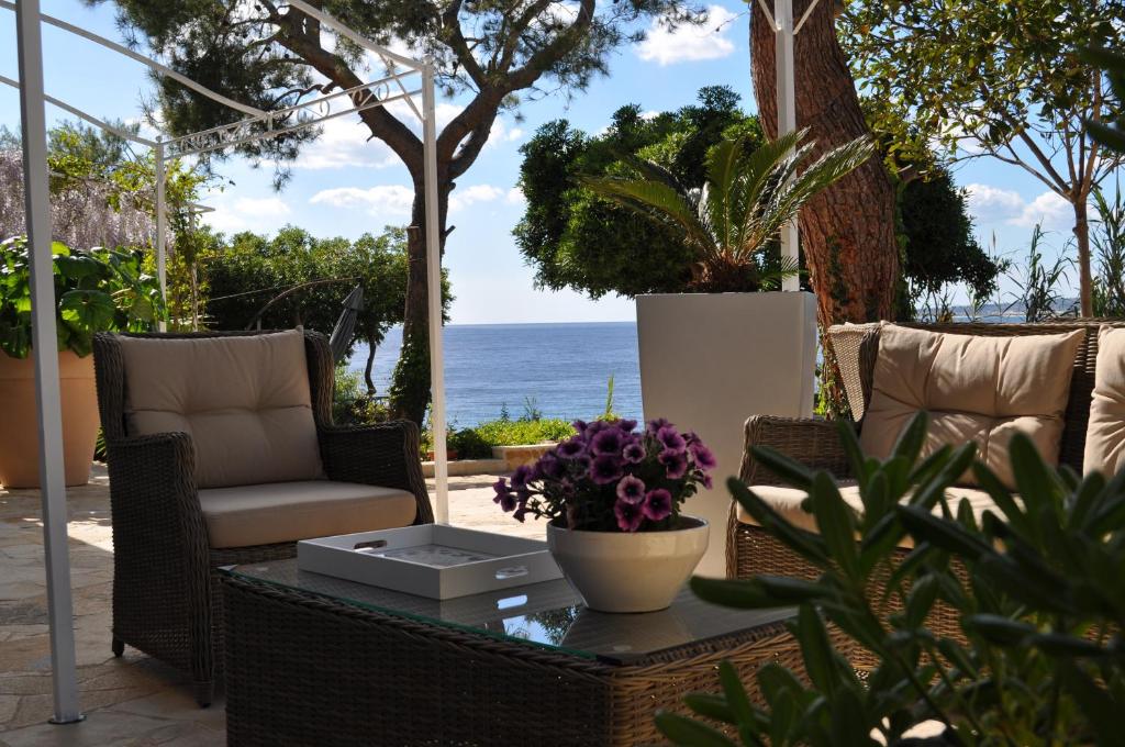 un patio con tavolo, sedie e vista sull'oceano di B&B ViaDelMare a Patù