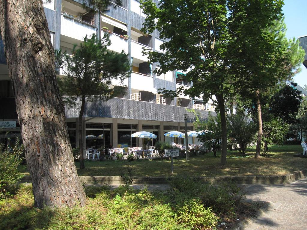 a building with tables and umbrellas in front of it at Appartamento A Mare in Grado