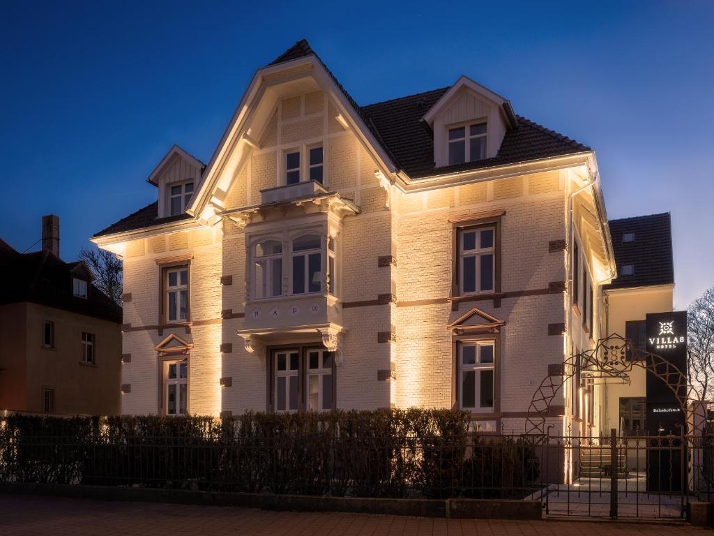 Una casa blanca con luces en la parte delantera. en Hotel Villa8 en Villingen-Schwenningen