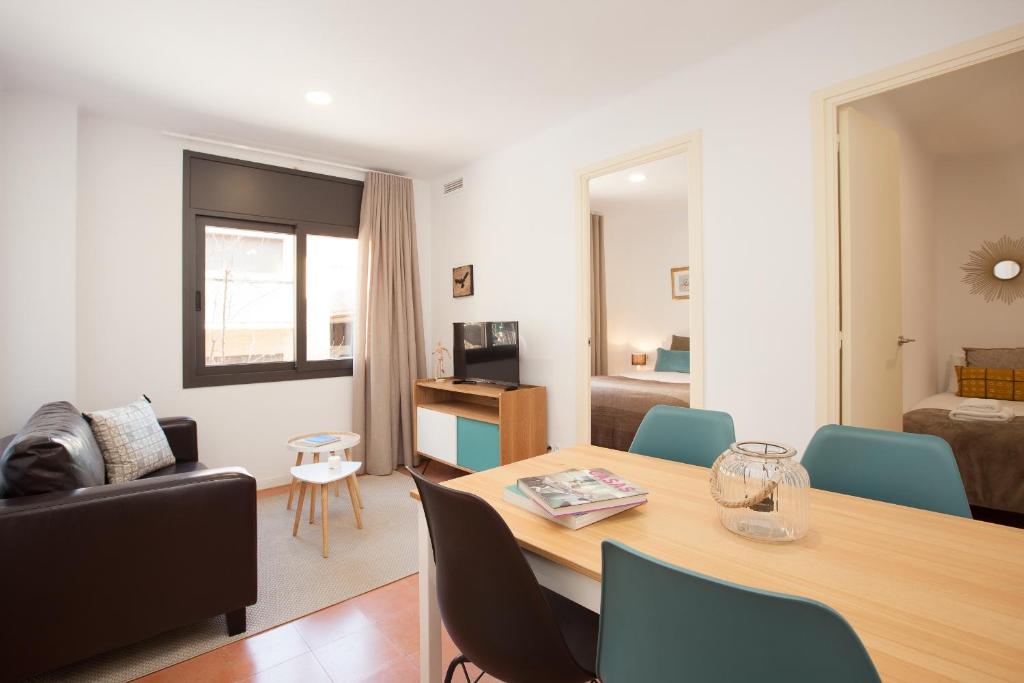 un soggiorno con tavolo e divano di Click&Flat Europa Fira Apartments a Hospitalet de Llobregat