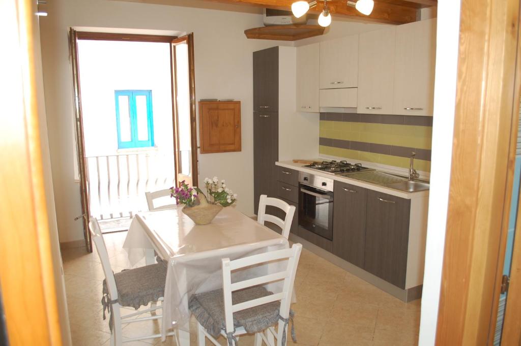 une cuisine avec une table et des chaises et une cuisine avec une fenêtre dans l'établissement Appartamento Il Soffio Di Eolo, à Lipari