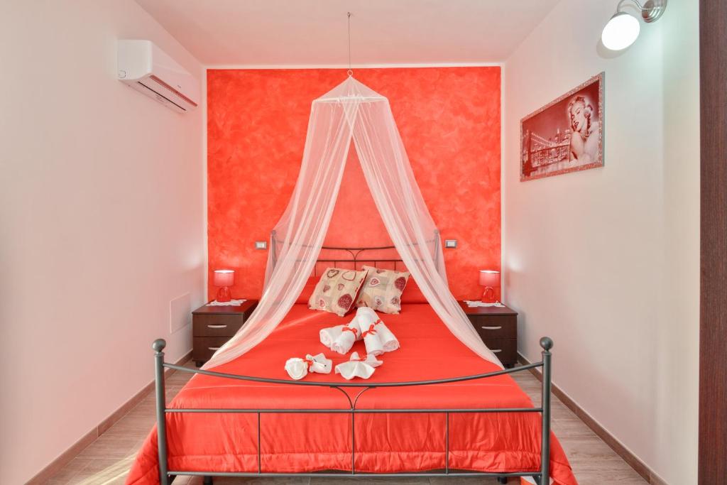 カステッラバーテにあるB&B Il Saliceのベッドルーム1室(赤いベッド1台、テディベア付)