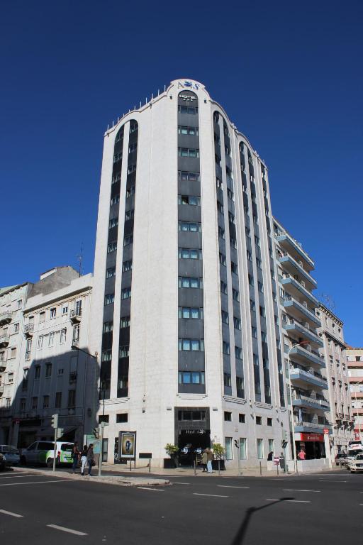 a tall white building on a city street at Hotel A.S. Lisboa in Lisbon