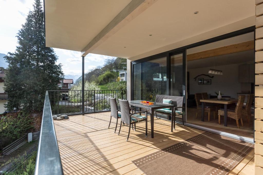 a patio with a table and chairs on a deck at Haus am Stein in Oetz