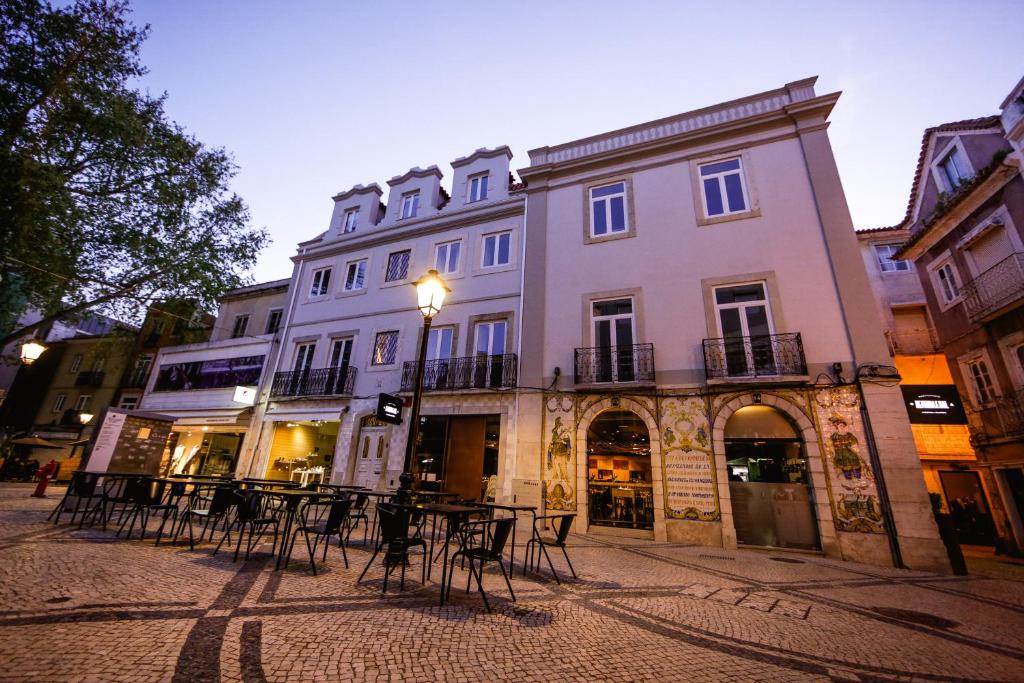 セトゥーバルにあるDe Pedra e Sal Hostel & Suitesの建物前のテーブルと椅子のある通り