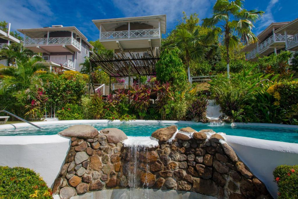 a pool at a resort with a waterfall at Oasis Marigot in Marigot Bay