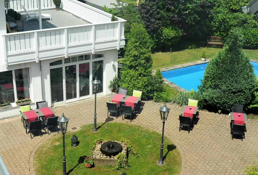 z widokiem na patio ze stołami i krzesłami oraz basenem w obiekcie Hotel Restaurant Sengscheider Hof w mieście St. Ingbert