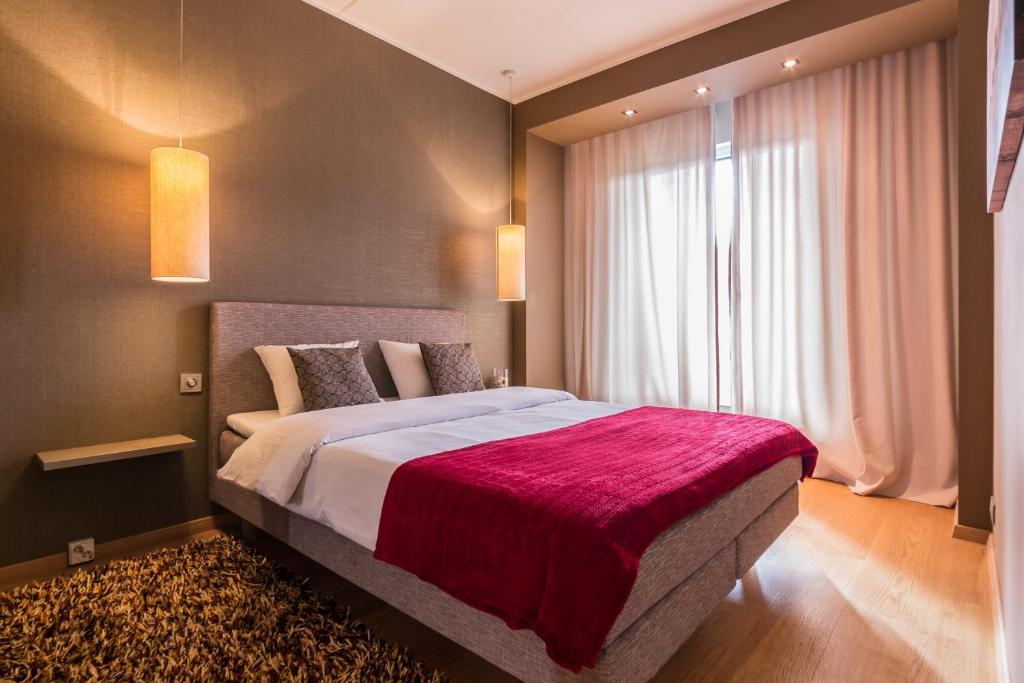 um quarto com uma cama grande e um cobertor vermelho em Hilltop Apartments - City Centre Foorum em Talin