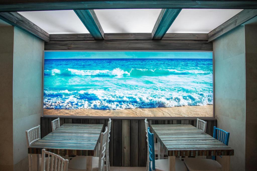 a painting of the ocean on the wall of a restaurant at Hotel Marqués del Mar in Mar del Plata