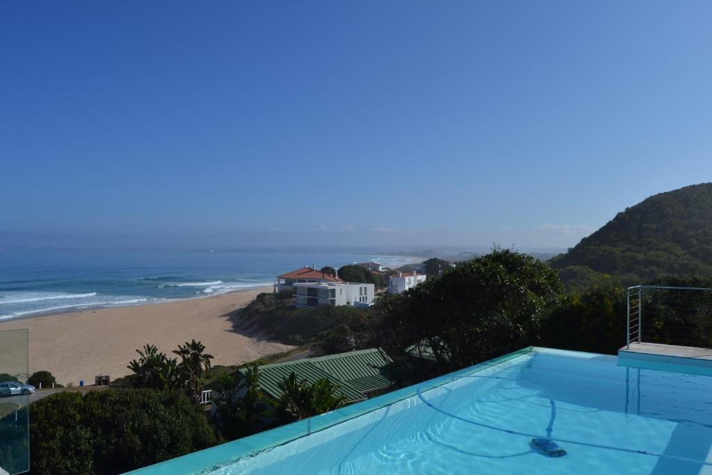 a swimming pool with a view of the beach at Villa Mare Nostrum in Plettenberg Bay
