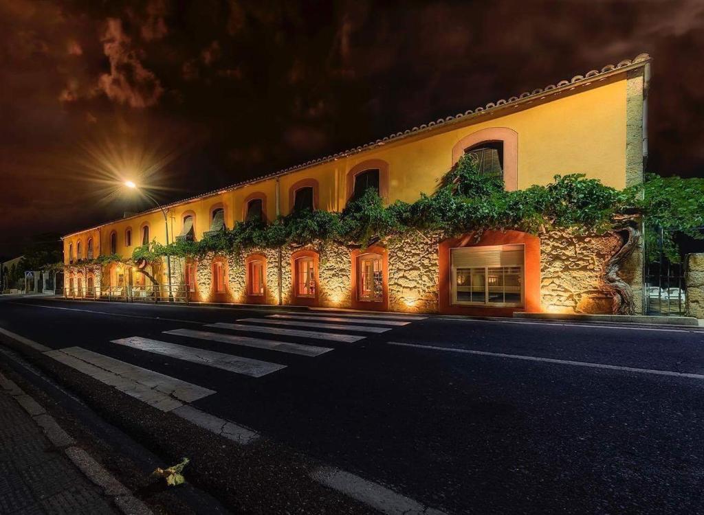 a building with plants on the side of it at night at Hotel Rural Eloy in Baños de Montemayor