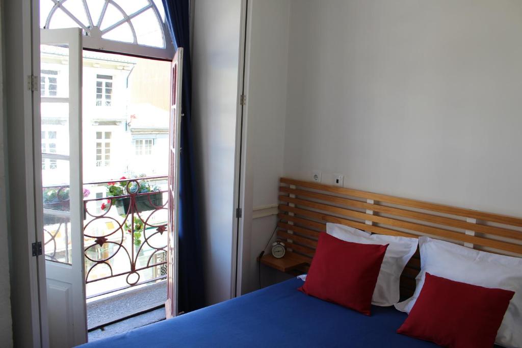 a bedroom with a blue bed and a balcony at Linha 22 in Porto