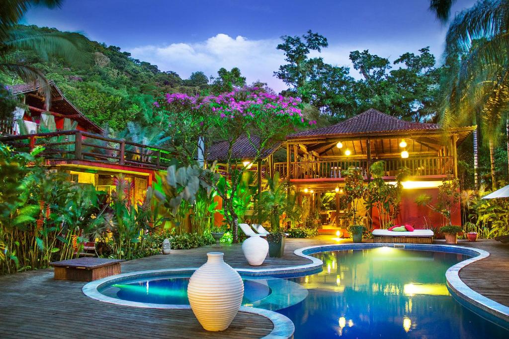 uma casa com piscina em frente a uma casa em Villa Manakás em Camburi