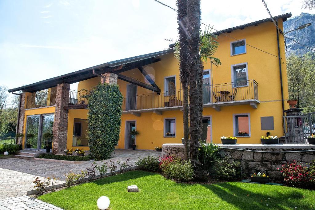 una casa amarilla con un jardín delante de ella en Il Portico, en Baveno