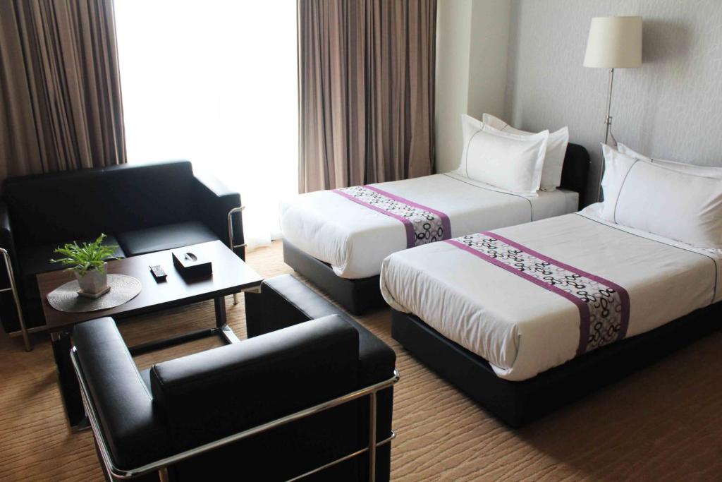 
a hotel room with two beds and two lamps at Symphony Suites Hotel in Ipoh
