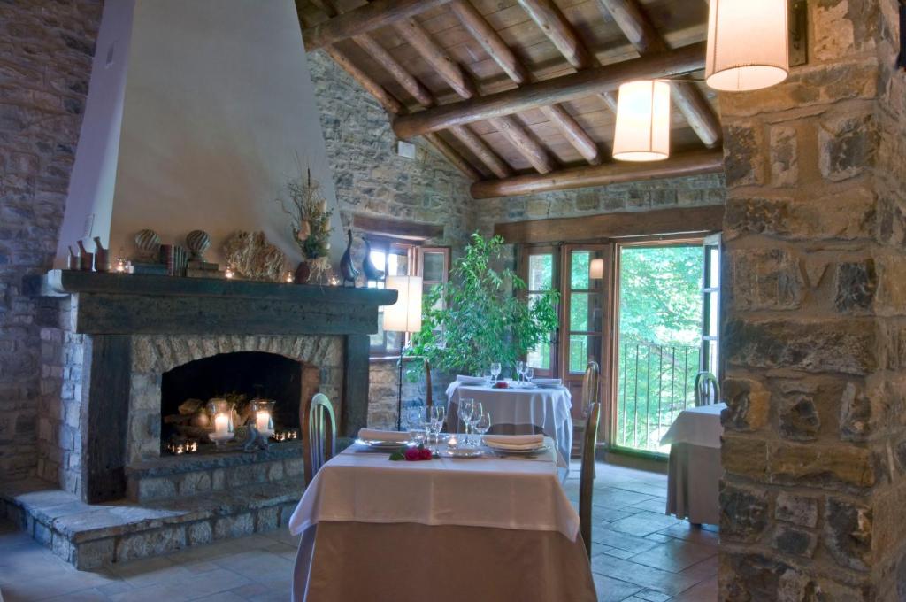 - un salon avec une cheminée en pierre et une table dans l'établissement Casa de San Martín, à San Martín De Solana