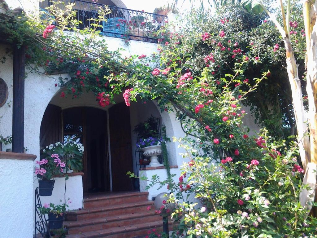 ein Haus mit Blumen auf der Vorderseite in der Unterkunft B&B Villa Piera Montecucco in Stintino