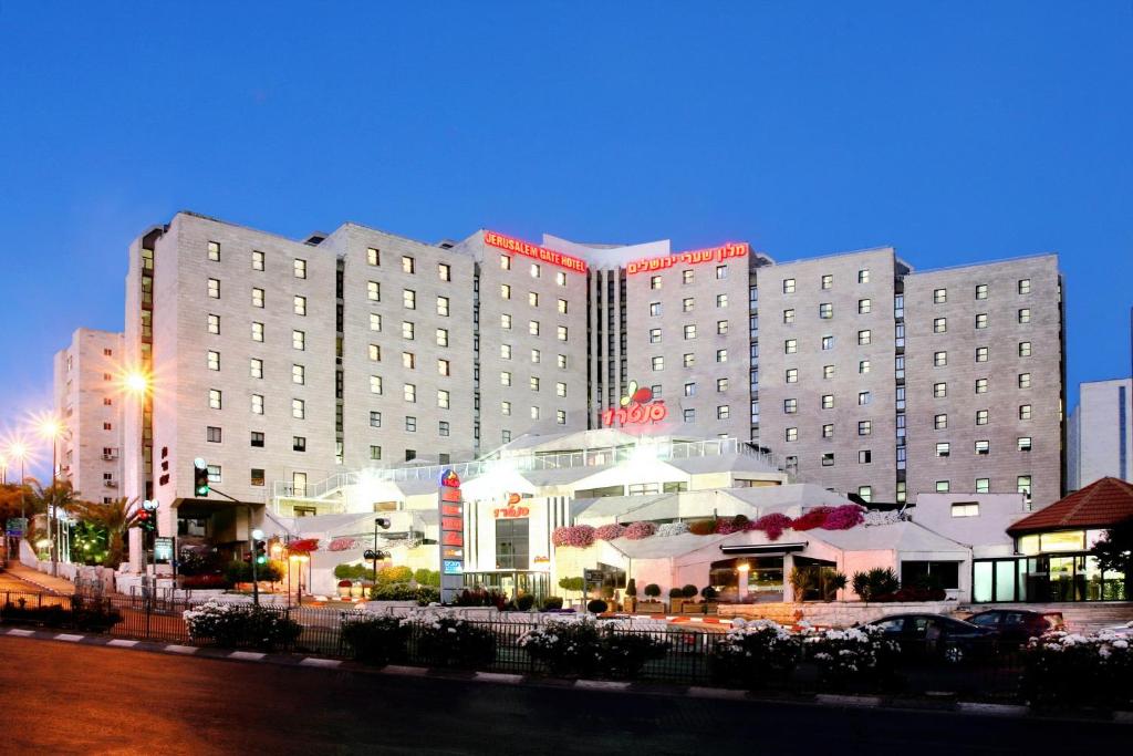 een groot hotelgebouw met een restaurant ervoor bij Jerusalem Gate Hotel in Jeruzalem