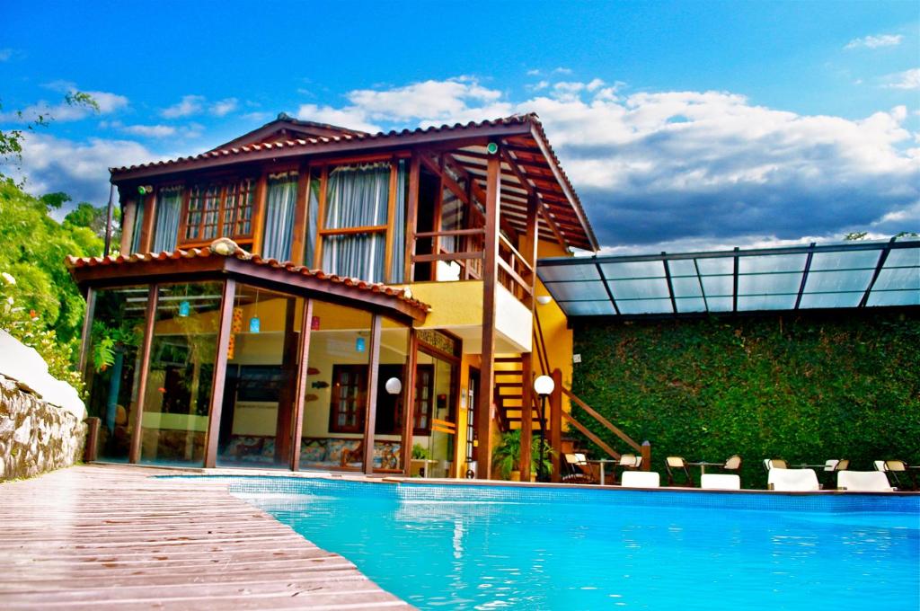 a house with a swimming pool in front of a house at Hotel Casa Encantada in Penedo