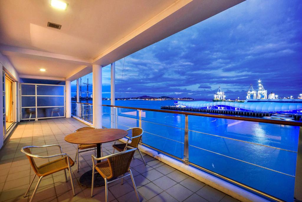 een balkon met een tafel en stoelen en uitzicht op de stad bij QV Private Waterfront Apartment - Princes Wharf - 379 in Auckland