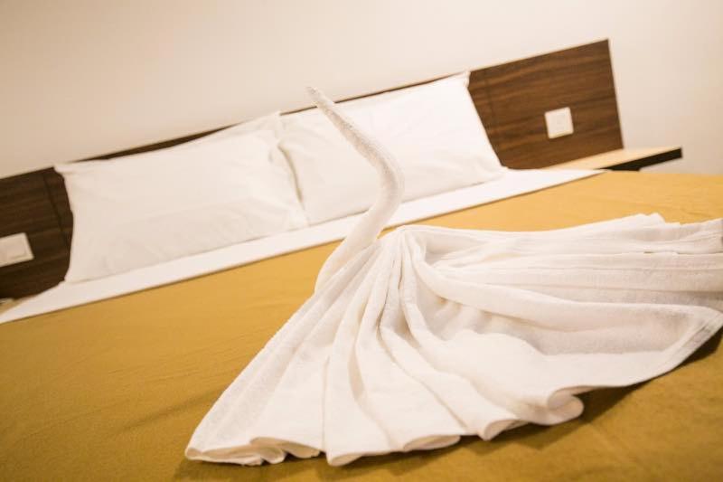a white dress sitting on top of a bed at Urban Inn, Jitra in Jitra