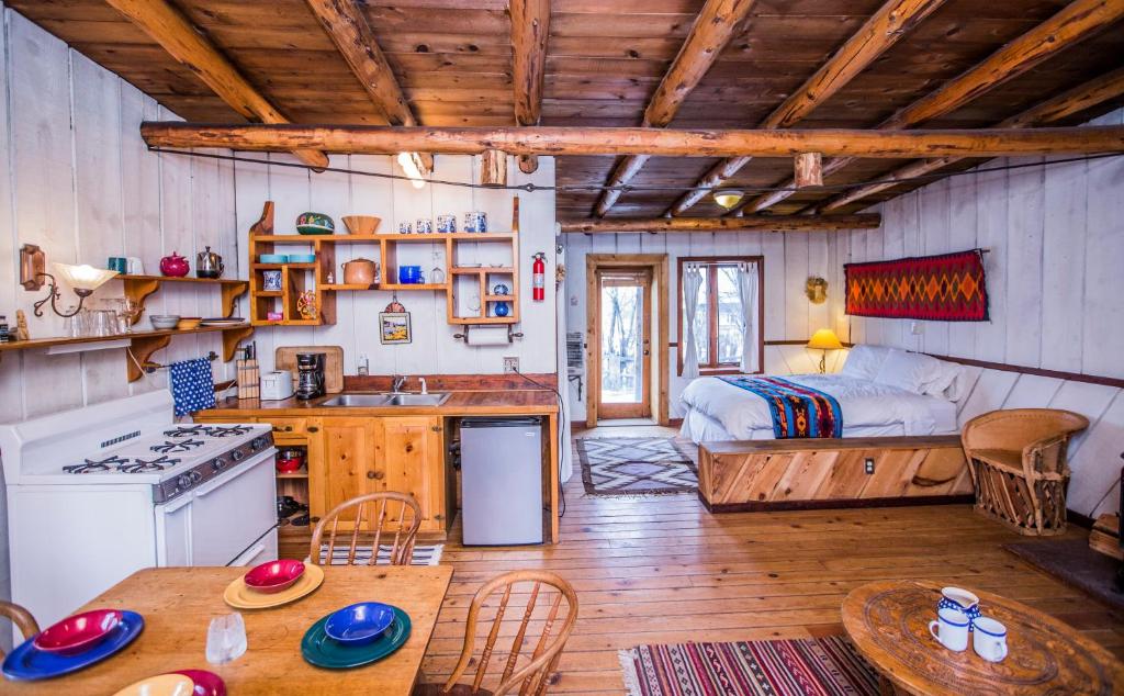 Taos Goji Farm & Eco-Lodge Retreat في Arroyo Seco: مطبخ وغرفة معيشة مع سرير في غرفة