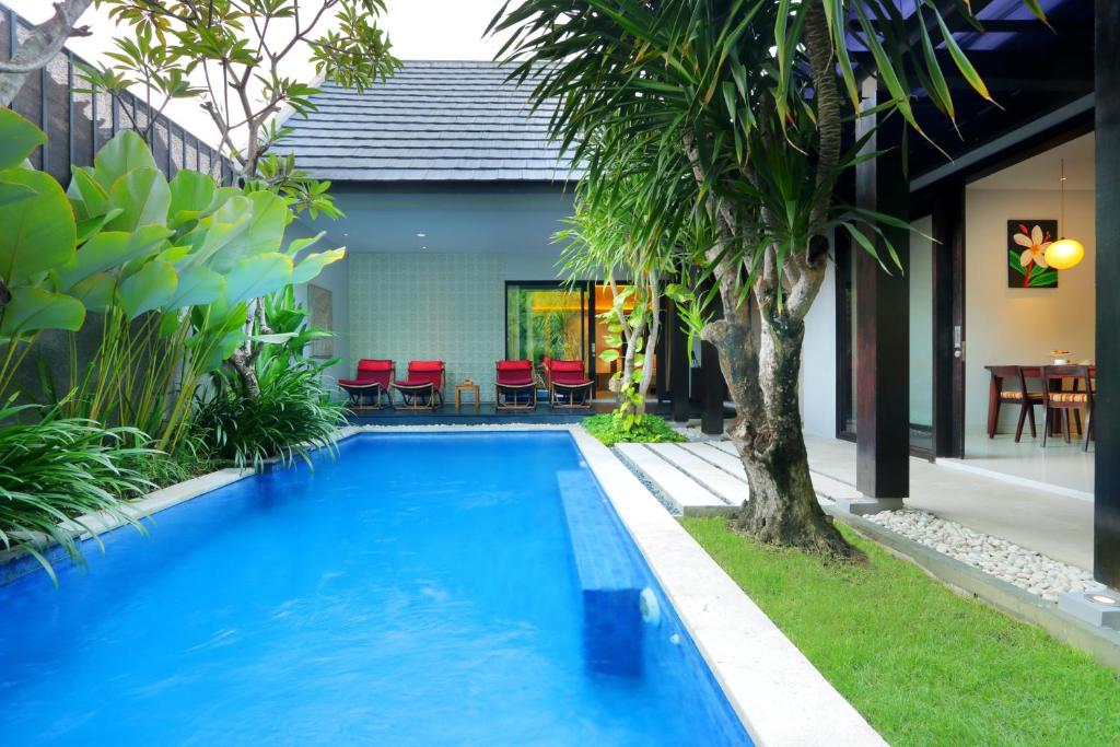 una piscina en medio de una casa en The Jineng Villas by Ekosistem, en Seminyak