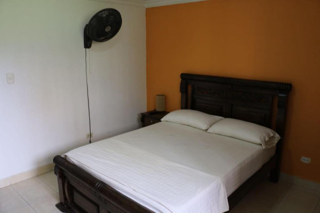 1 cama en un dormitorio con reloj en la pared en Apartamento buritaca 302 el rodadero, en Santa Marta