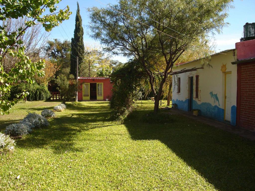un cortile con una casa, un albero e un prato di Posada Arco Iris a San Marcos Sierra