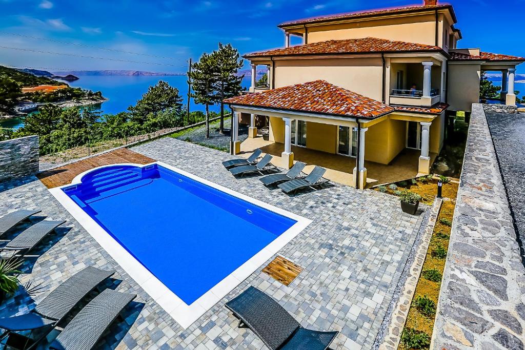 a villa with a swimming pool and a house at Apartments Mia in Sveti Juraj