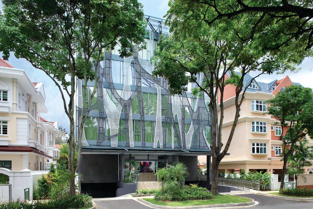 una fachada de cristal de un edificio con árboles en ST Residences Novena, en Singapur