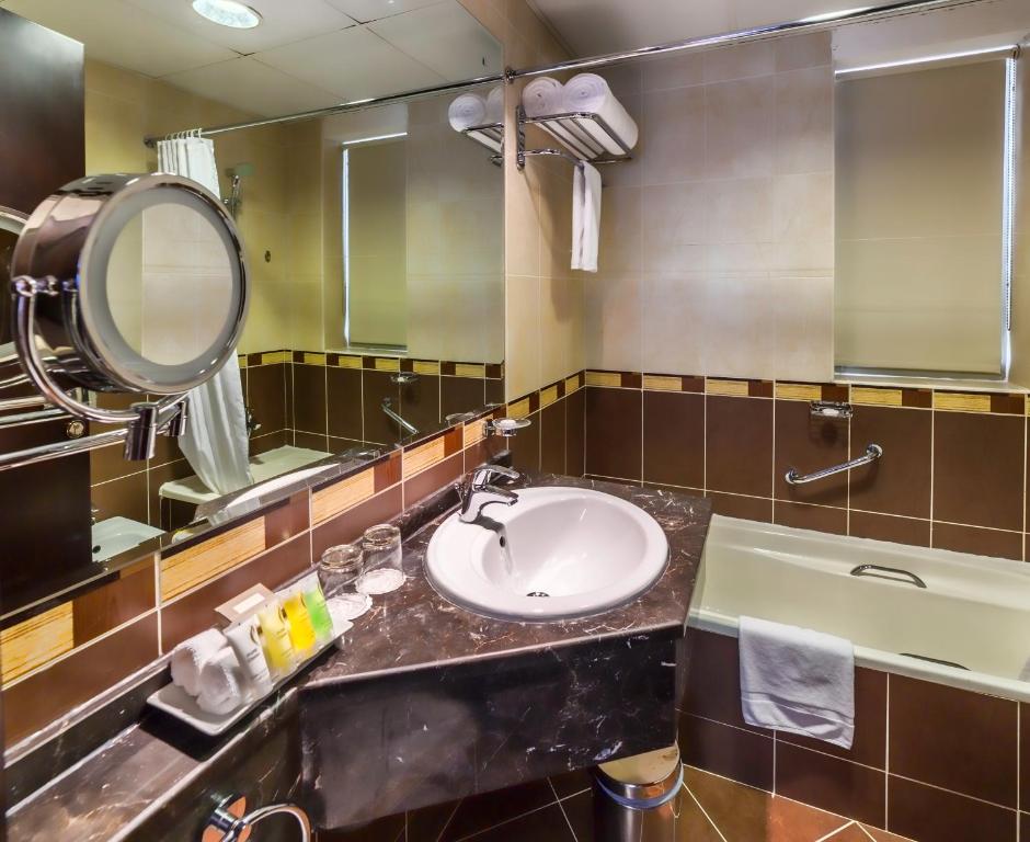 a bathroom with a sink and a mirror at Executive Suites Abu Dhabi in Abu Dhabi